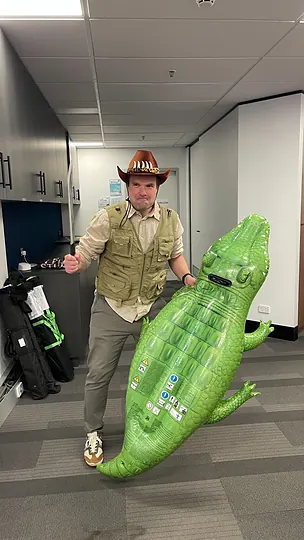 A colleague carrying an inflatable crocodile through the office in a cowboy hat.