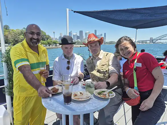 Colleagues over lunch on Sydney Harbour, the Harbour Bridge behind them.