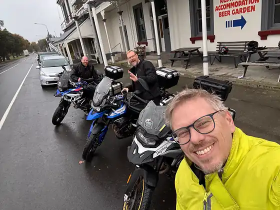 A colleague at the head of a line of motorcycles outside a country pub.