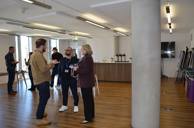 Colleagues standing and talking between sessions in the Sydney office.