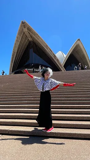 A colleague on the steps of the Sydney Opera House, arms wide.