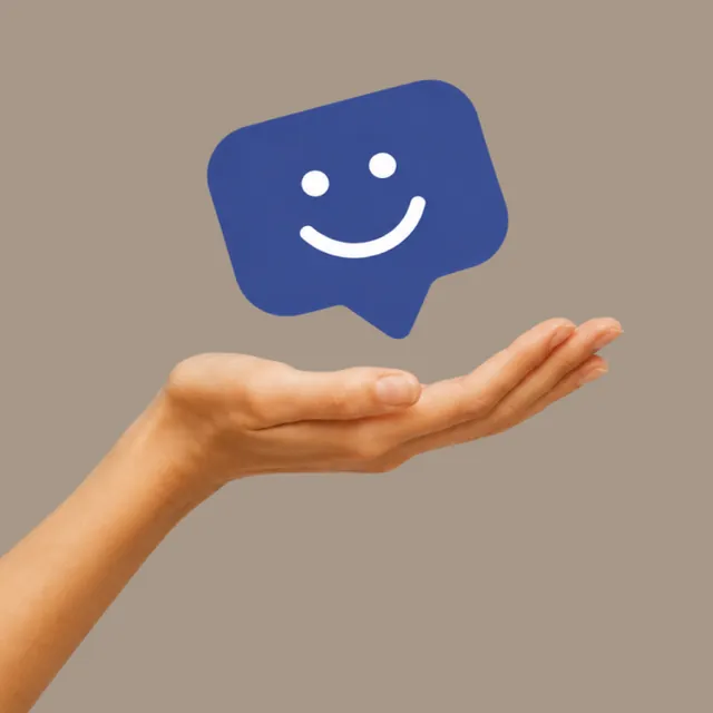 An open palm holding a smiling blue chat bubble